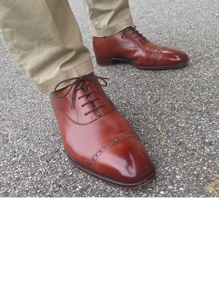 Туфли на этой фотографии не очень хорошо подходят своему владельцу по колодке (обратите внимание на складки на левом ботинке)